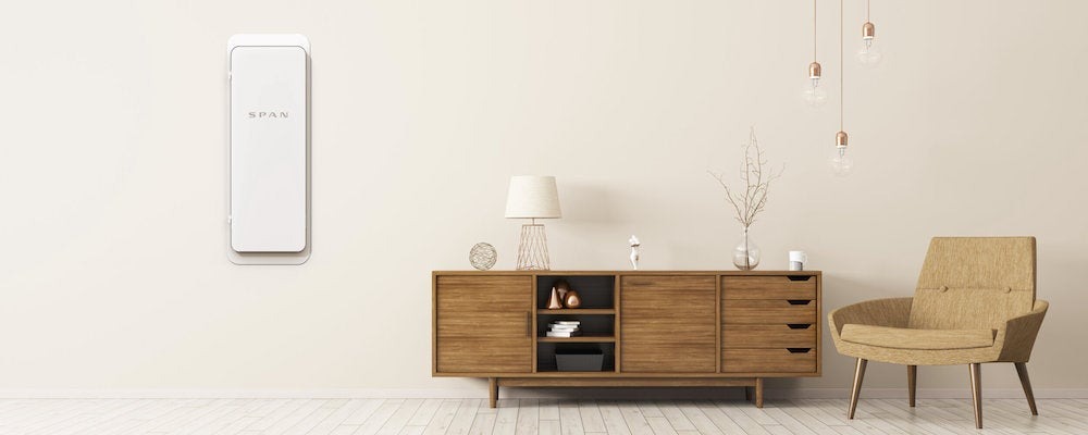 A photo of a modern living room with a Span electrical panel on the wall